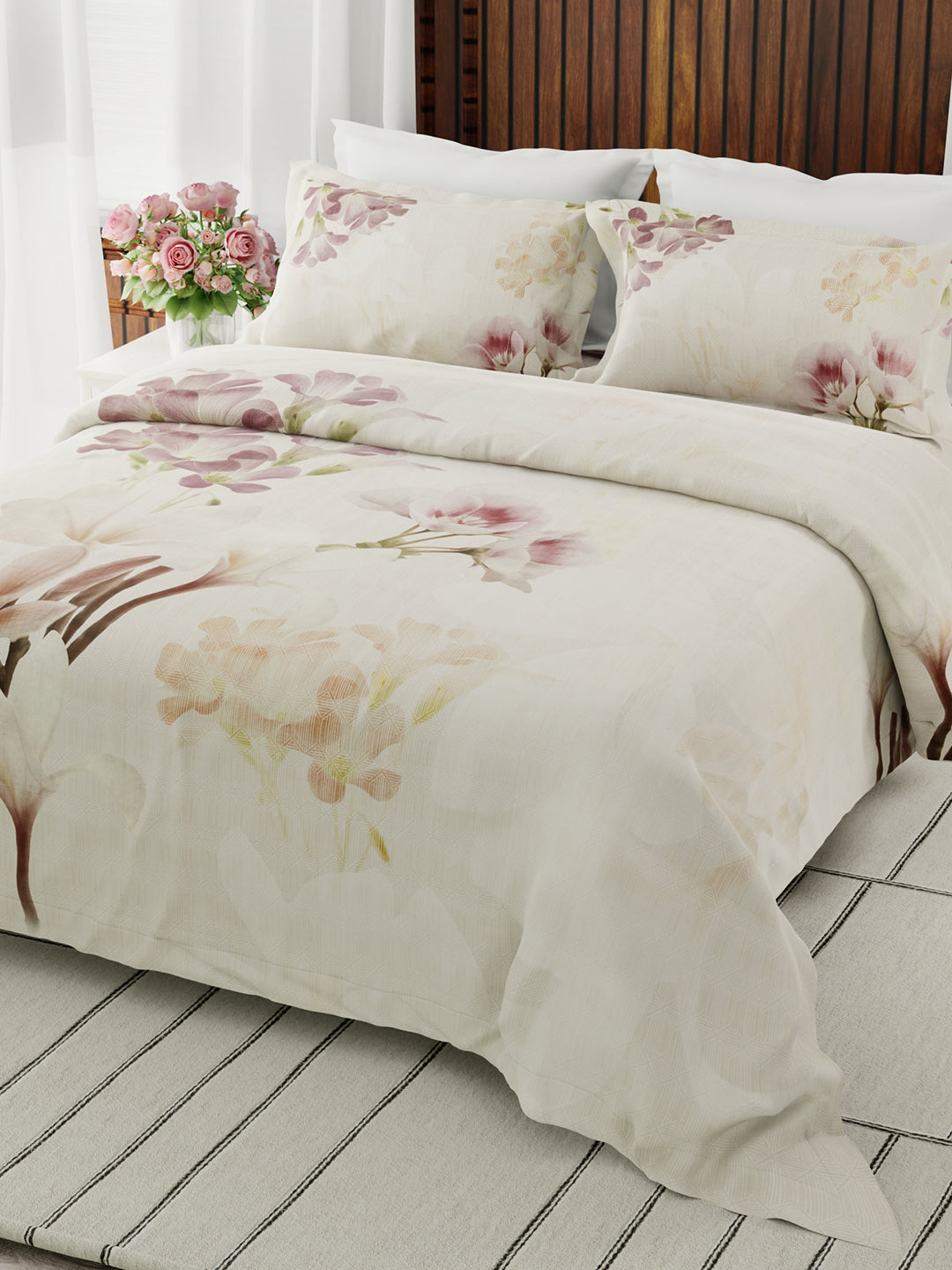Floral patterned bedding set on a bed with a wooden headboard.