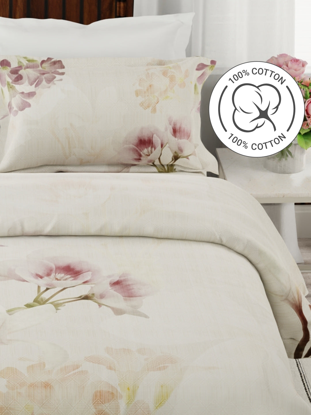 Floral bedding set with a '100% Cotton' label on a bed.
