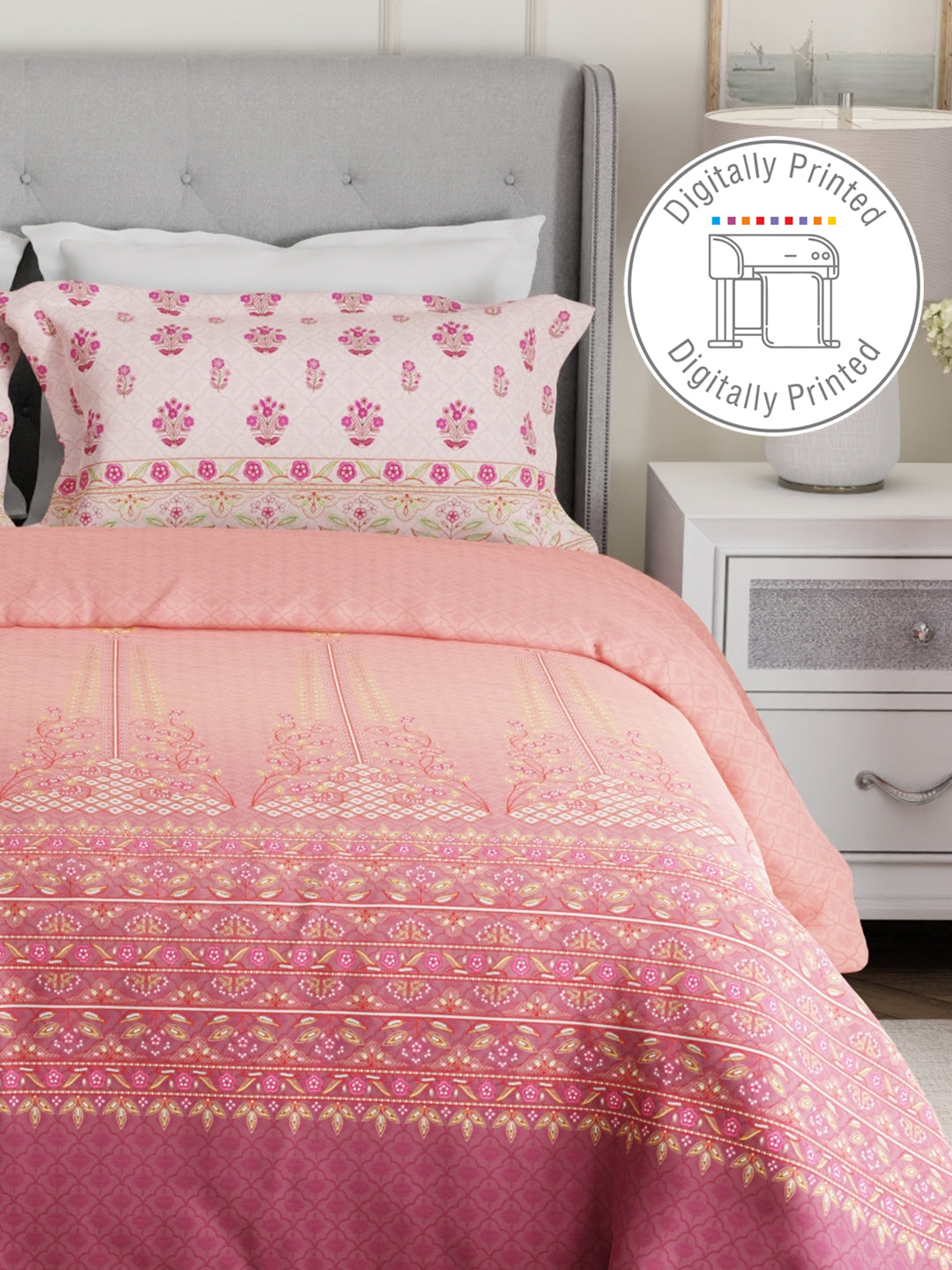 Pink and white patterned bedding set on a bed with a nightstand in the background.