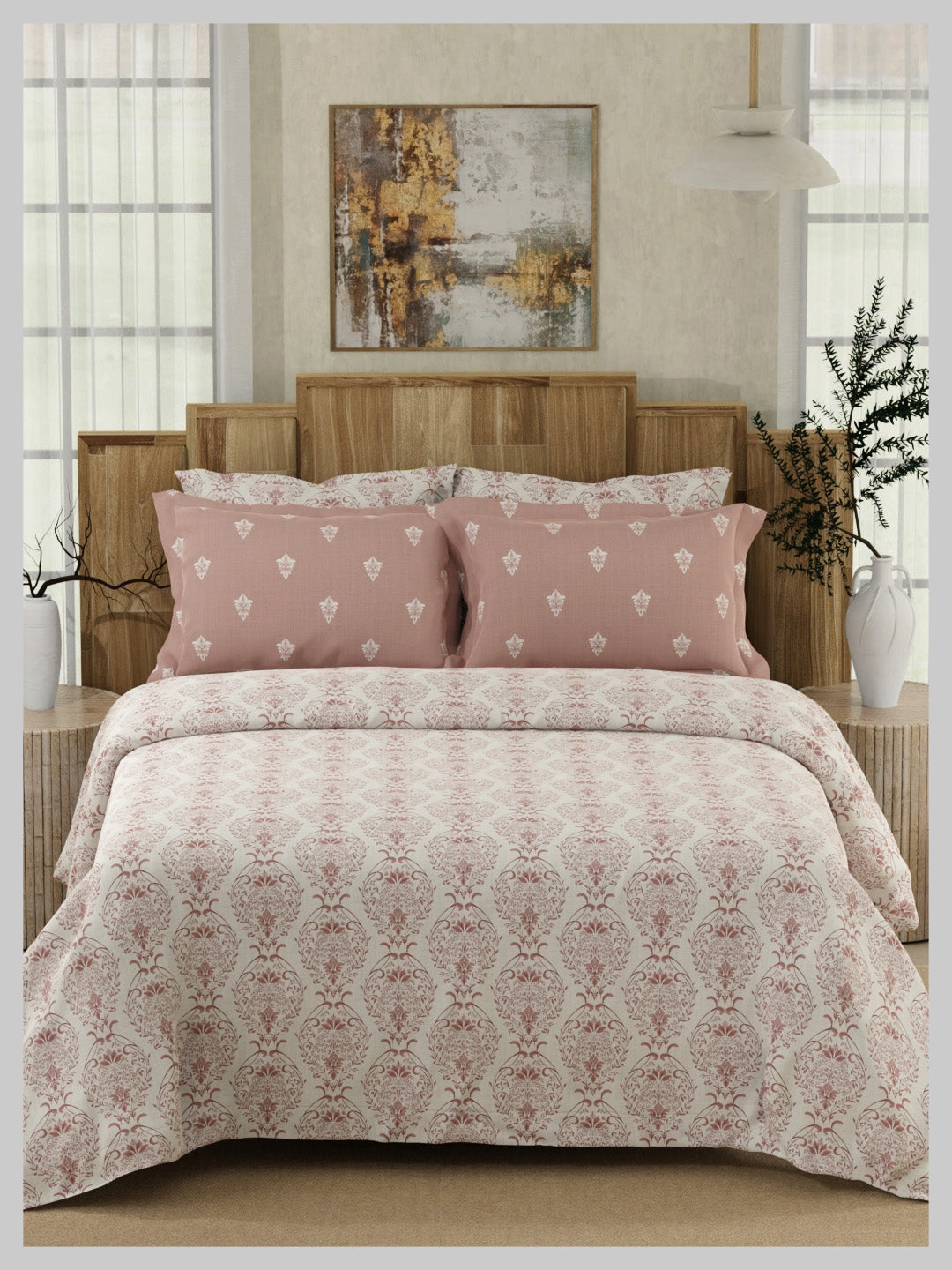 Bed with pink and white patterned bedding in a bedroom setting.