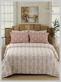 Bed with pink and white patterned bedding in a bedroom setting.