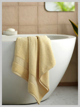 Beige towel draped over a white bathtub in a bathroom setting